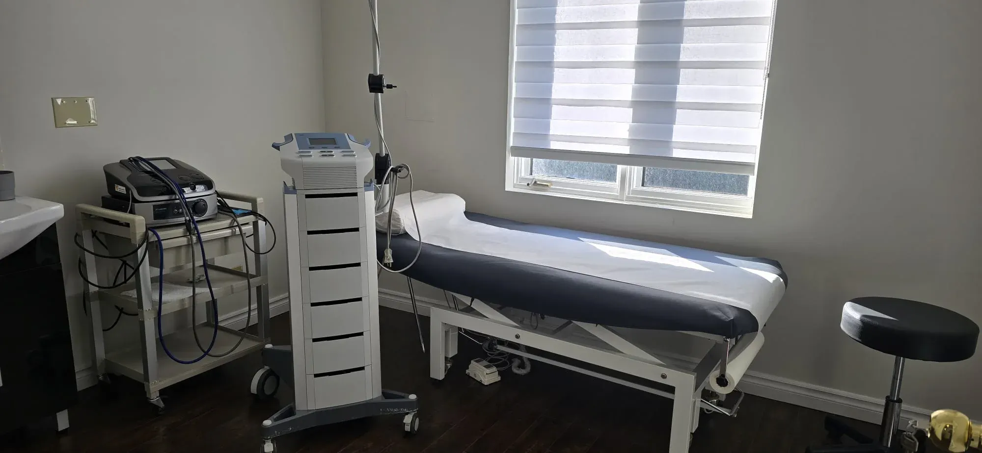 A bright private treatment room with therapy equipment at Physiotrust